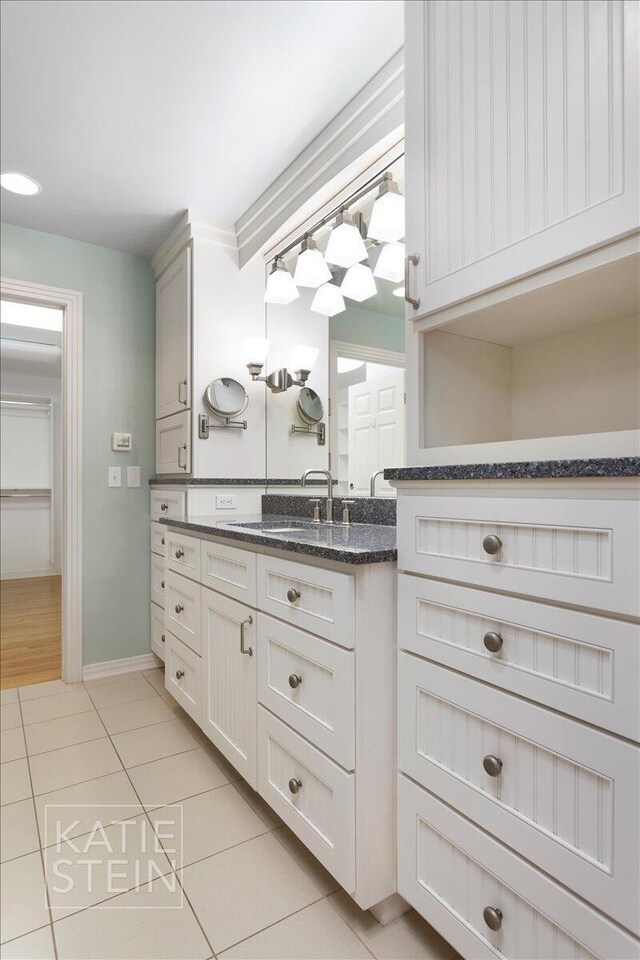 bathroom with vanity, tile patterned flooring, and baseboards