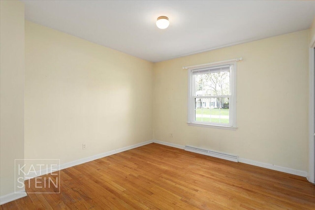 unfurnished room featuring baseboards, a baseboard radiator, and light wood finished floors