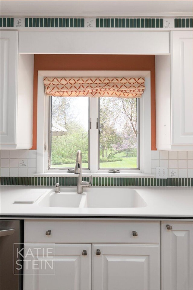 kitchen with white cabinetry, visible vents, a sink, and tasteful backsplash