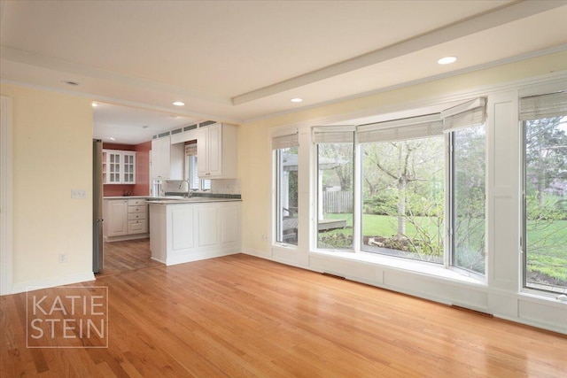 kitchen featuring light wood-type flooring, a peninsula, and a wealth of natural light