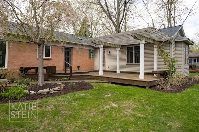 rear view of house featuring a lawn, a pergola, a wooden deck, and brick siding