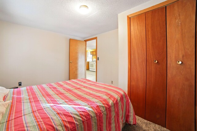 carpeted bedroom featuring a textured ceiling and a closet