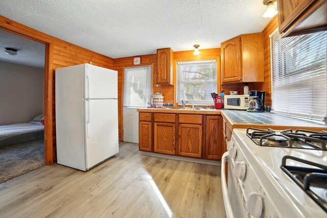 kitchen featuring a sink, tile countertops, white appliances, and a textured ceiling