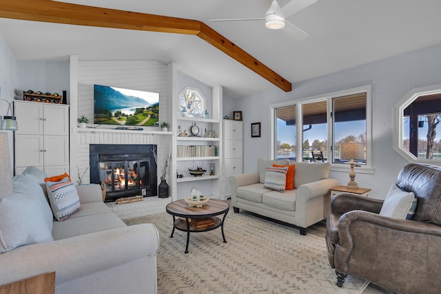 1704 Little Dr, Horton, MI 49246 - living room with lofted ceiling with beams, ceiling fan, a fireplace, and a wealth of natural light