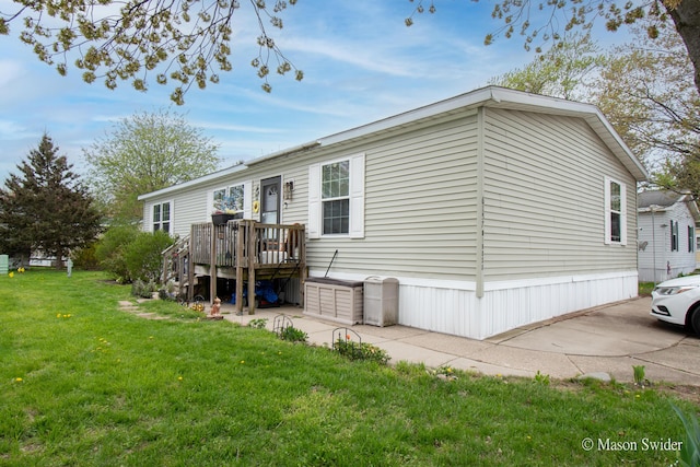 rear view of house featuring a yard and a deck