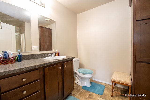 bathroom featuring vanity, baseboards, toilet, and tile patterned flooring