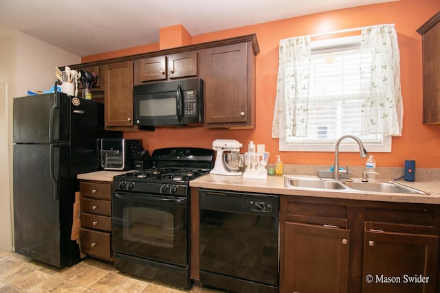 kitchen featuring a sink, light countertops, dark brown cabinetry, and black appliances