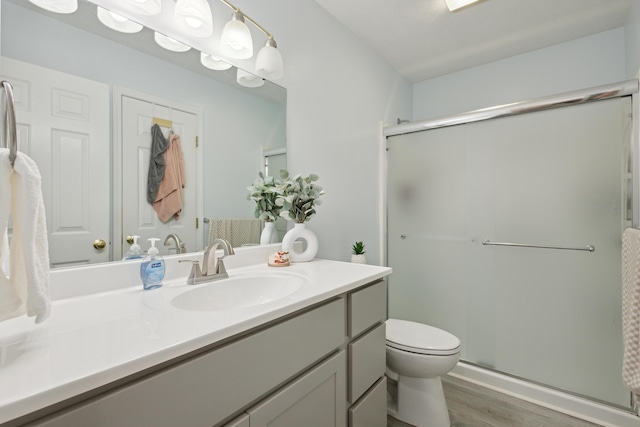 3332 Hampton Downs Dr SE, Kentwood, MI 49512 - full bathroom featuring toilet, a shower stall, wood finished floors, and vanity