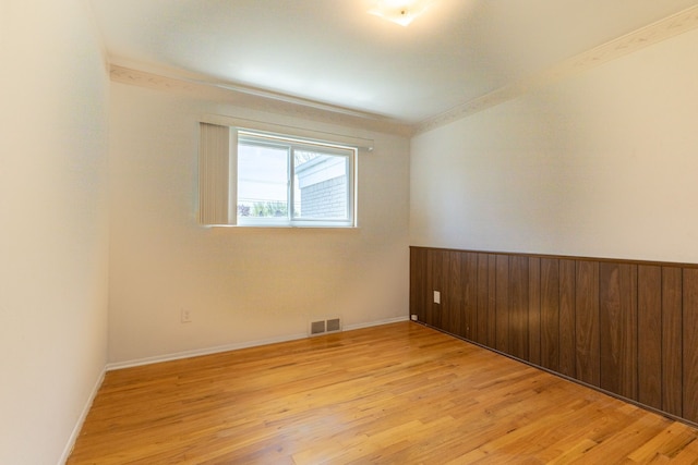 empty room featuring baseboards, visible vents, and light wood-style floors