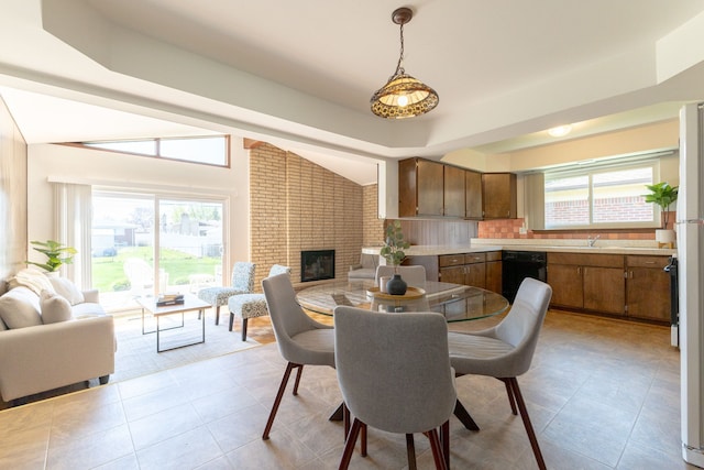 dining area featuring plenty of natural light, a brick fireplace, and light tile patterned flooring
