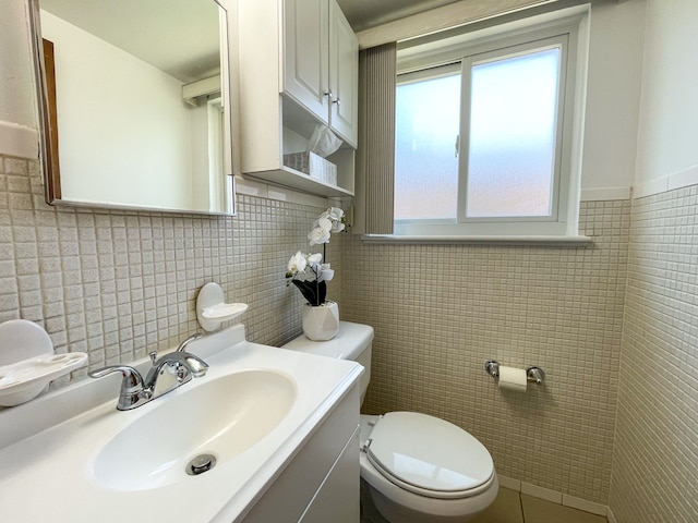 bathroom featuring vanity, toilet, and tile walls