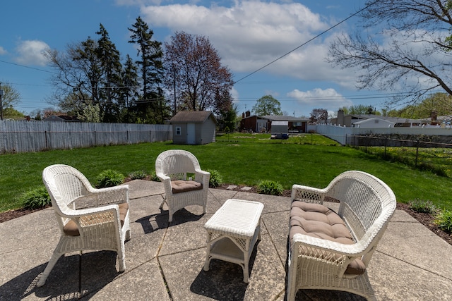 view of patio / terrace with a fenced backyard, a shed, and an outbuilding