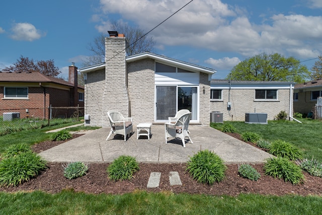 back of house with a yard, central AC, a chimney, and a patio area