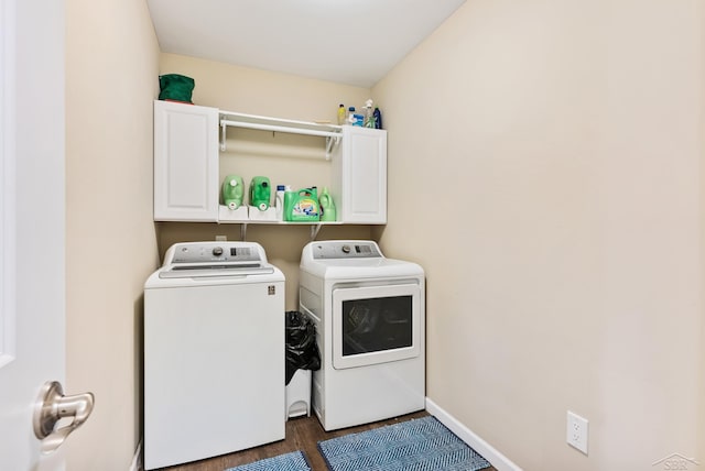 laundry room featuring cabinet space, separate washer and dryer, baseboards, and wood finished floors