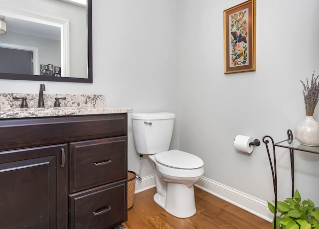 1605 Lloyd Ave, Royal Oak, MI 48073 - half bathroom featuring wood finished floors, baseboards, toilet, and vanity