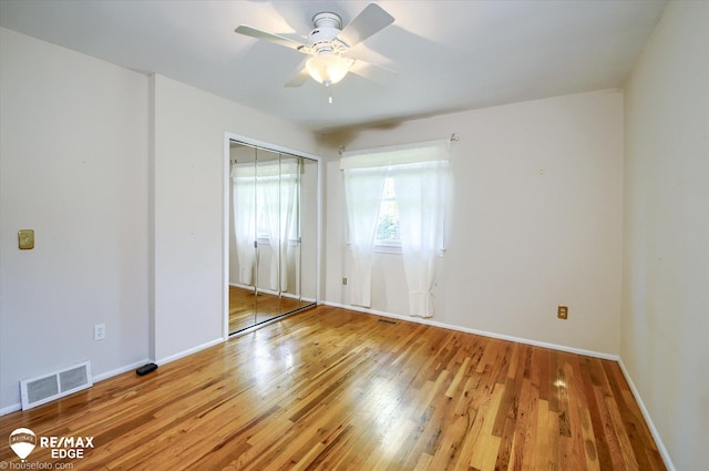 spare room with light wood-style floors, baseboards, ceiling fan, and visible vents