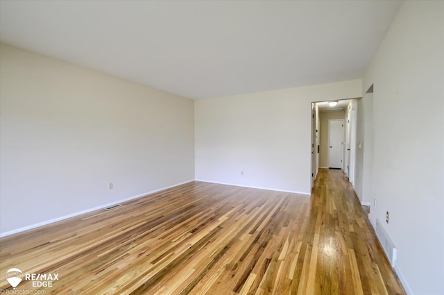spare room with visible vents, light wood-style flooring, and baseboards
