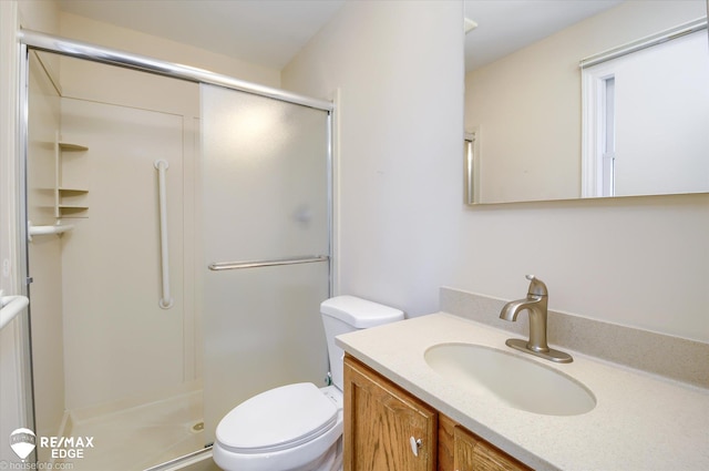 bathroom with vanity, toilet, and a stall shower