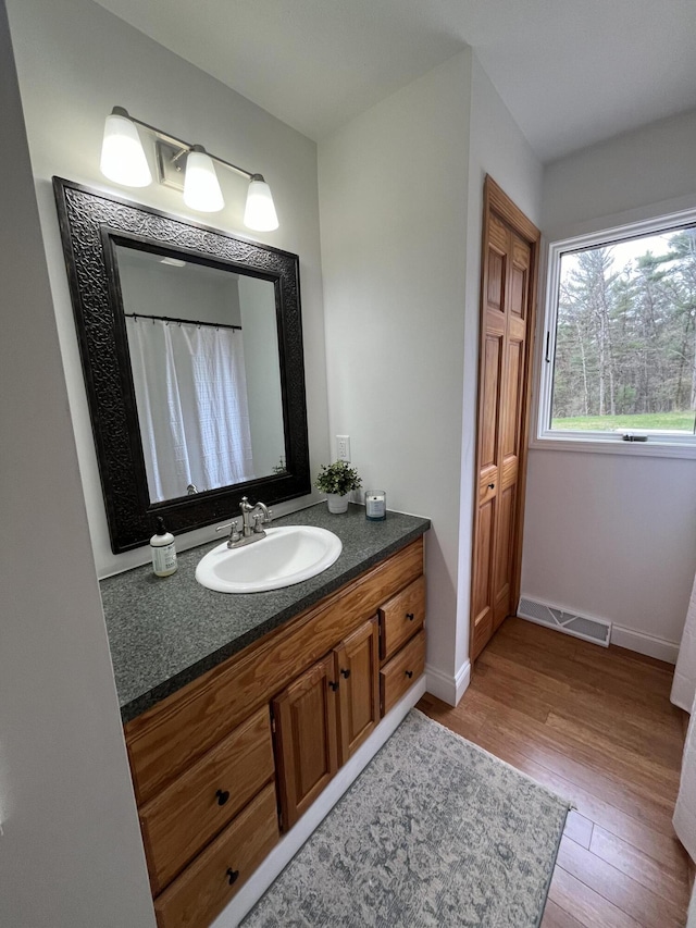 full bathroom featuring visible vents, baseboards, wood finished floors, and vanity