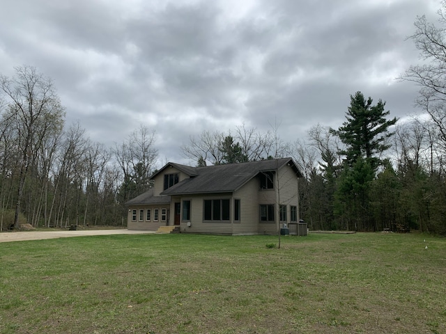 view of front of property featuring a front lawn, central air condition unit, and concrete driveway