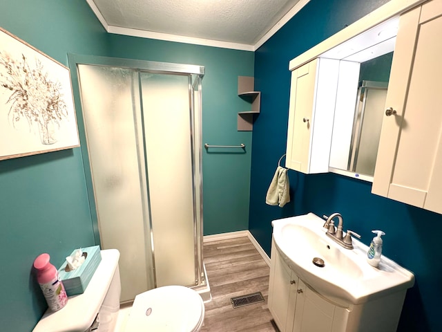 full bath featuring a textured ceiling, visible vents, a stall shower, wood finished floors, and toilet
