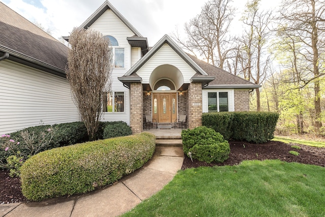 view of front of house featuring brick siding and a shingled roof