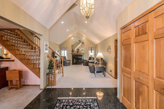 foyer entrance featuring a fireplace, baseboards, stairway, carpet flooring, and granite finish floor