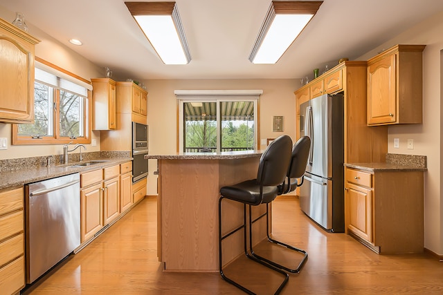 kitchen featuring a center island, a sink, plenty of natural light, and stainless steel appliances