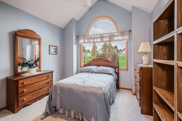 bedroom featuring baseboards, light carpet, and lofted ceiling