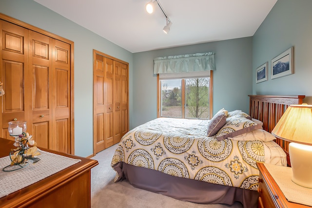 carpeted bedroom with rail lighting
