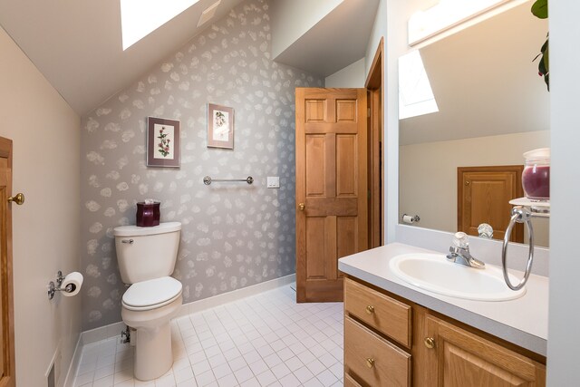 bathroom with tile patterned flooring, vanity, toilet, lofted ceiling with skylight, and wallpapered walls