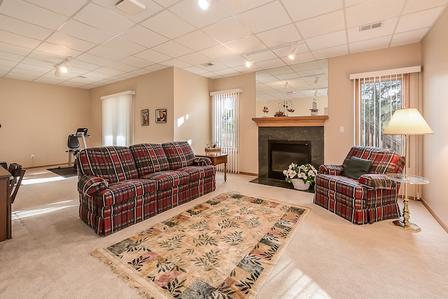 carpeted living area with visible vents, rail lighting, baseboards, and a tile fireplace