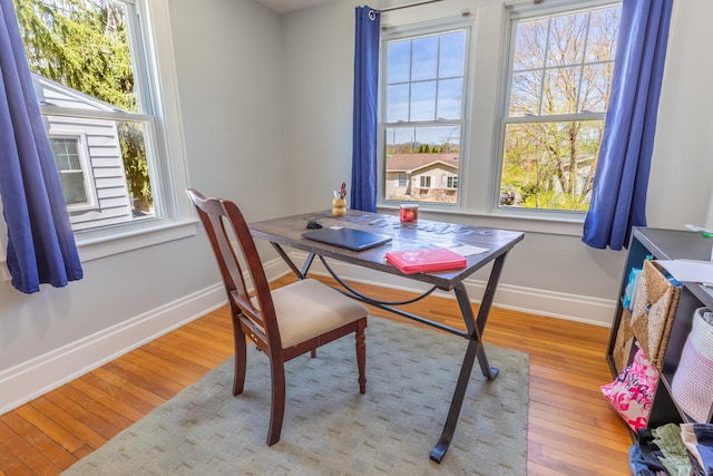 dining space featuring baseboards and light wood-style flooring