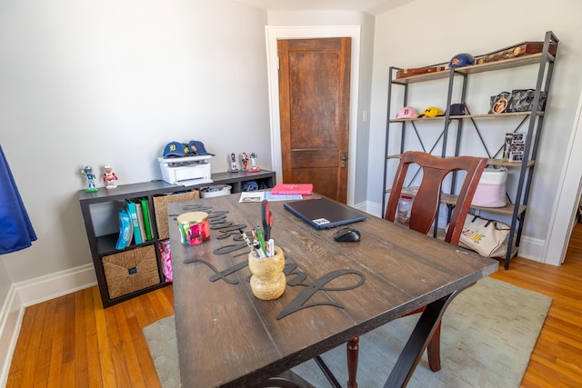 home office with baseboards and wood finished floors