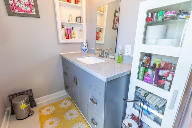 bathroom with baseboards, tile patterned flooring, and vanity