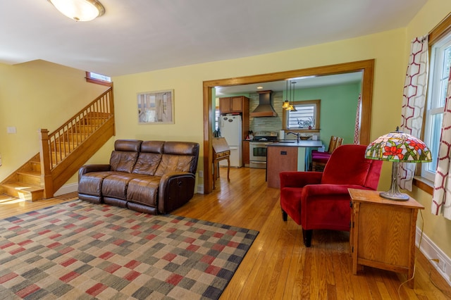 living room with stairway, wood-type flooring, and a healthy amount of sunlight