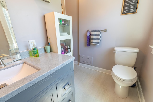 bathroom featuring vanity, baseboards, and toilet