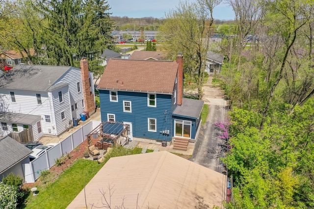 back of house featuring a fenced backyard, a chimney, entry steps, and a residential view