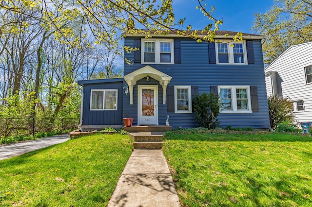 colonial inspired home featuring fence and a front yard