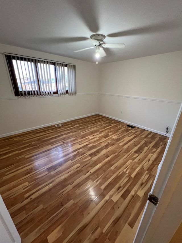 36125 Beverly Dr, Sterling Heights, MI 48310 - unfurnished room with baseboards, a ceiling fan, wood finished floors, and visible vents