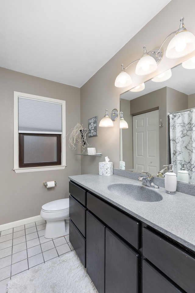 full bath with toilet, tile patterned floors, baseboards, and vanity