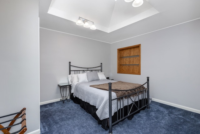 bedroom featuring carpet flooring, baseboards, and a raised ceiling