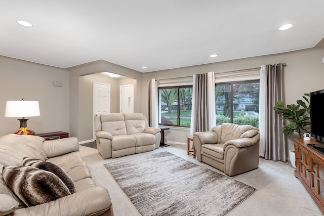 living area featuring recessed lighting, baseboards, and light carpet