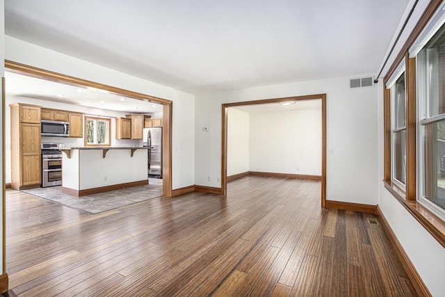 unfurnished living room featuring visible vents, recessed lighting, wood-type flooring, and baseboards