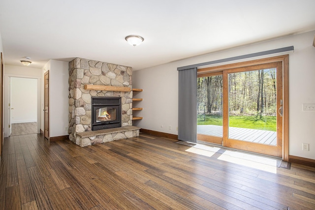 unfurnished living room featuring baseboards, dark wood finished floors, and a fireplace