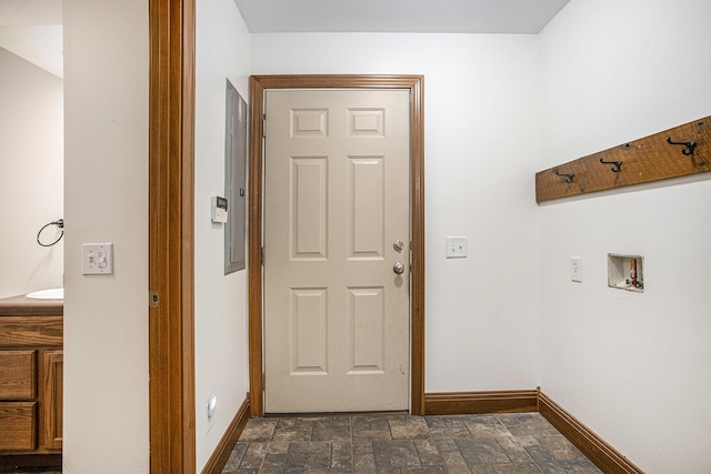 washroom with stone finish floor, baseboards, laundry area, and hookup for a washing machine