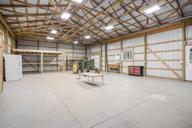 garage featuring metal wall and freestanding refrigerator