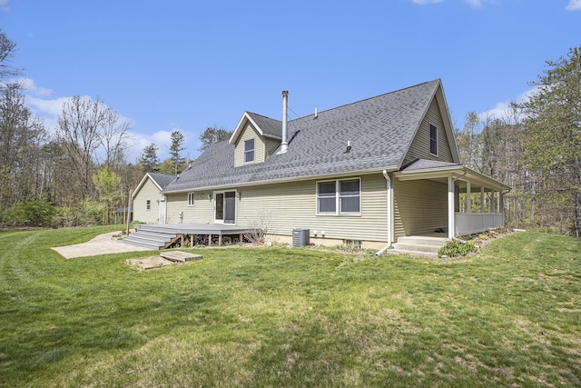 rear view of house featuring a lawn, a shingled roof, and a patio area