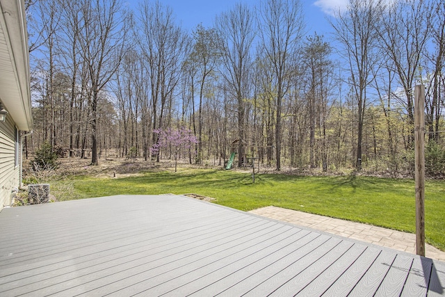 wooden deck featuring a playground and a yard