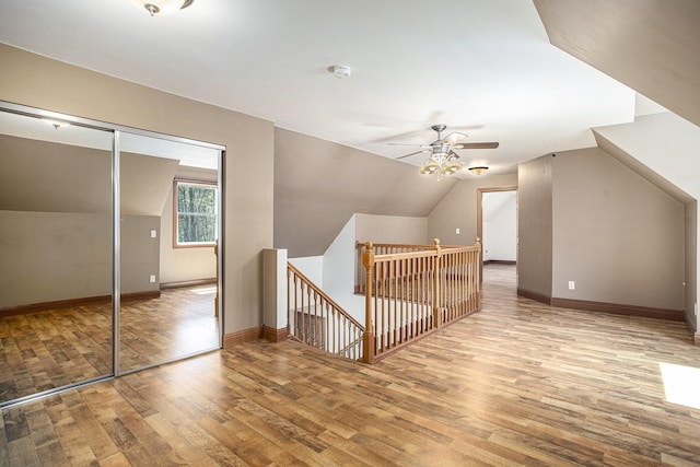 additional living space featuring baseboards, a ceiling fan, lofted ceiling, and wood finished floors